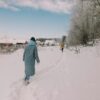 man in gray jacket walking on snow covered ground during daytime