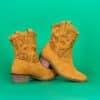 a pair of yellow cowboy boots on a green background