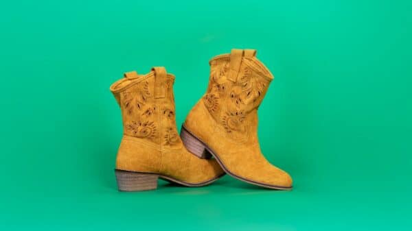 a pair of yellow cowboy boots on a green background