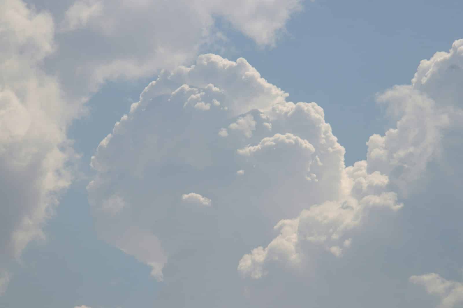 A plane flying in the sky with a lot of clouds