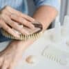 a woman brushes her nails with a brush