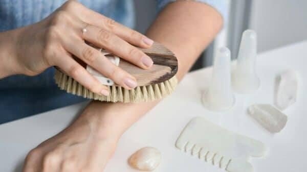 a woman brushes her nails with a brush