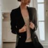 woman in black blazer standing near white wall