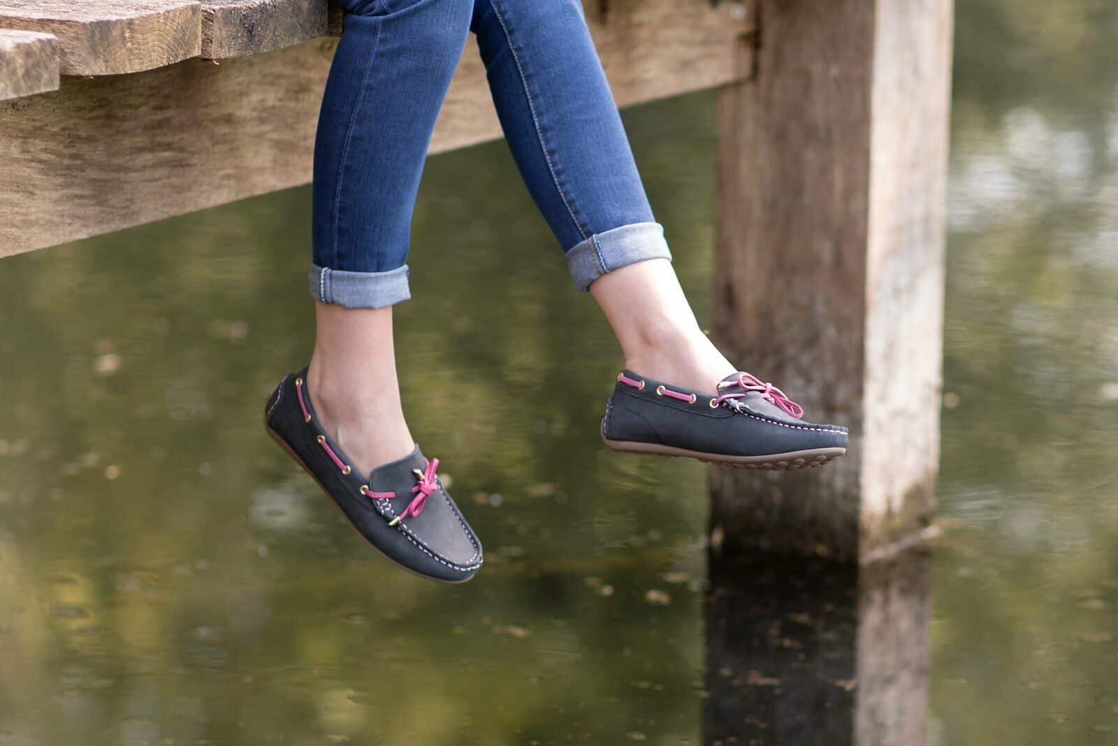 a woman's feet hanging off the edge of a dock