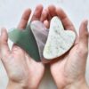 two hands holding two heart shaped pieces of soap