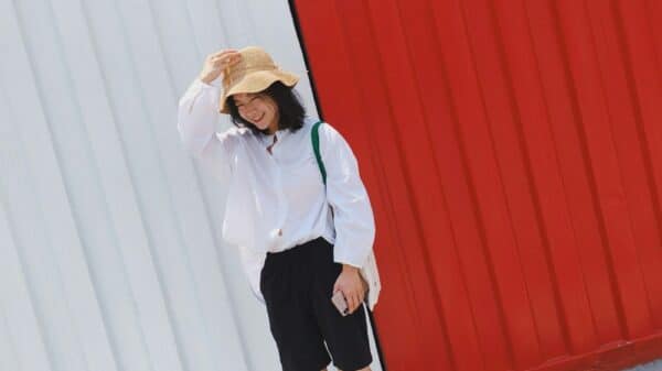 smiling woman standing beside red and white wall