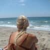 Woman with braided blonde hair on sandy beach