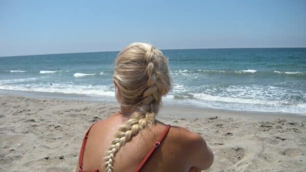 Woman with braided blonde hair on sandy beach