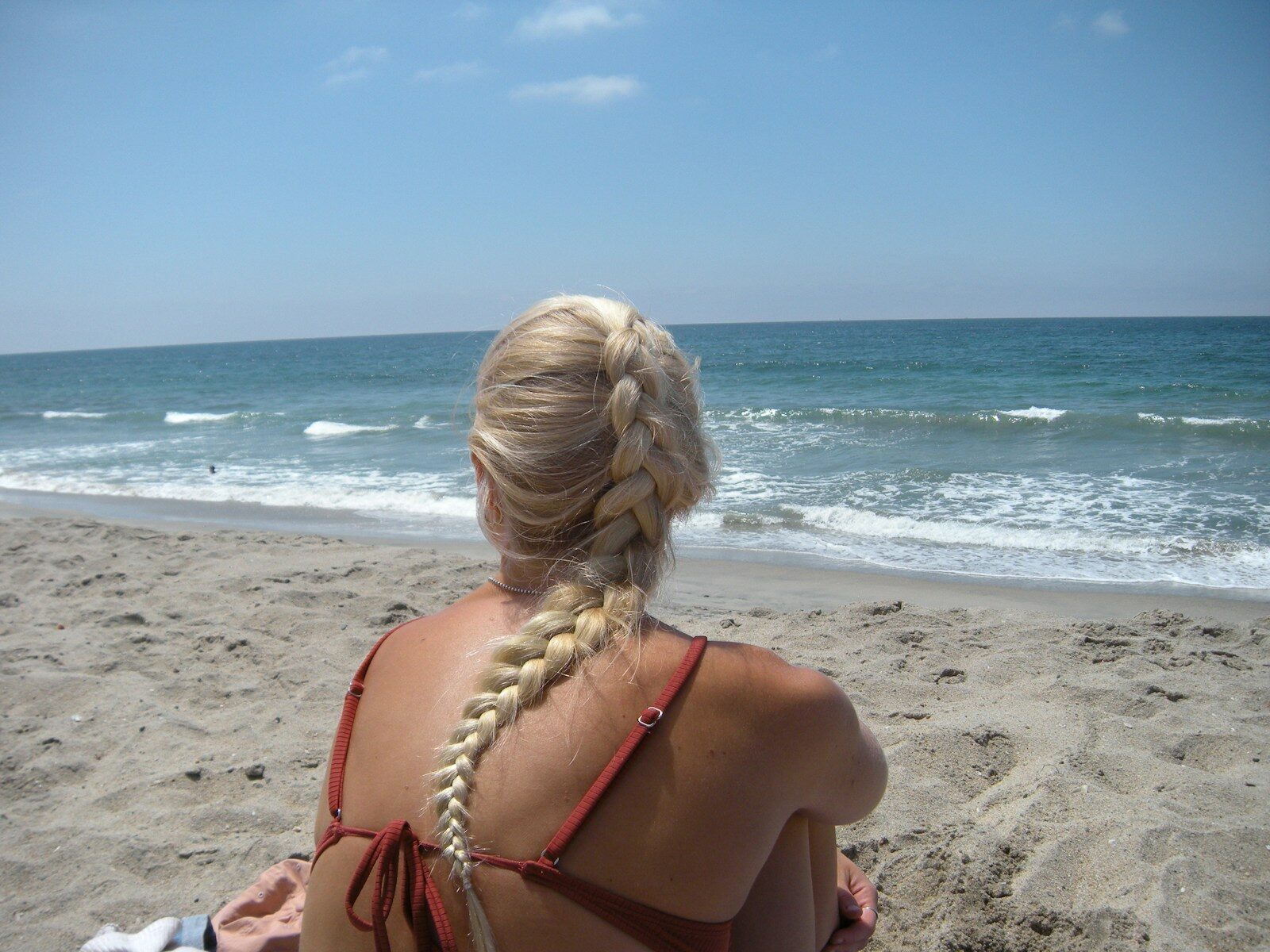 Woman with braided blonde hair on sandy beach
