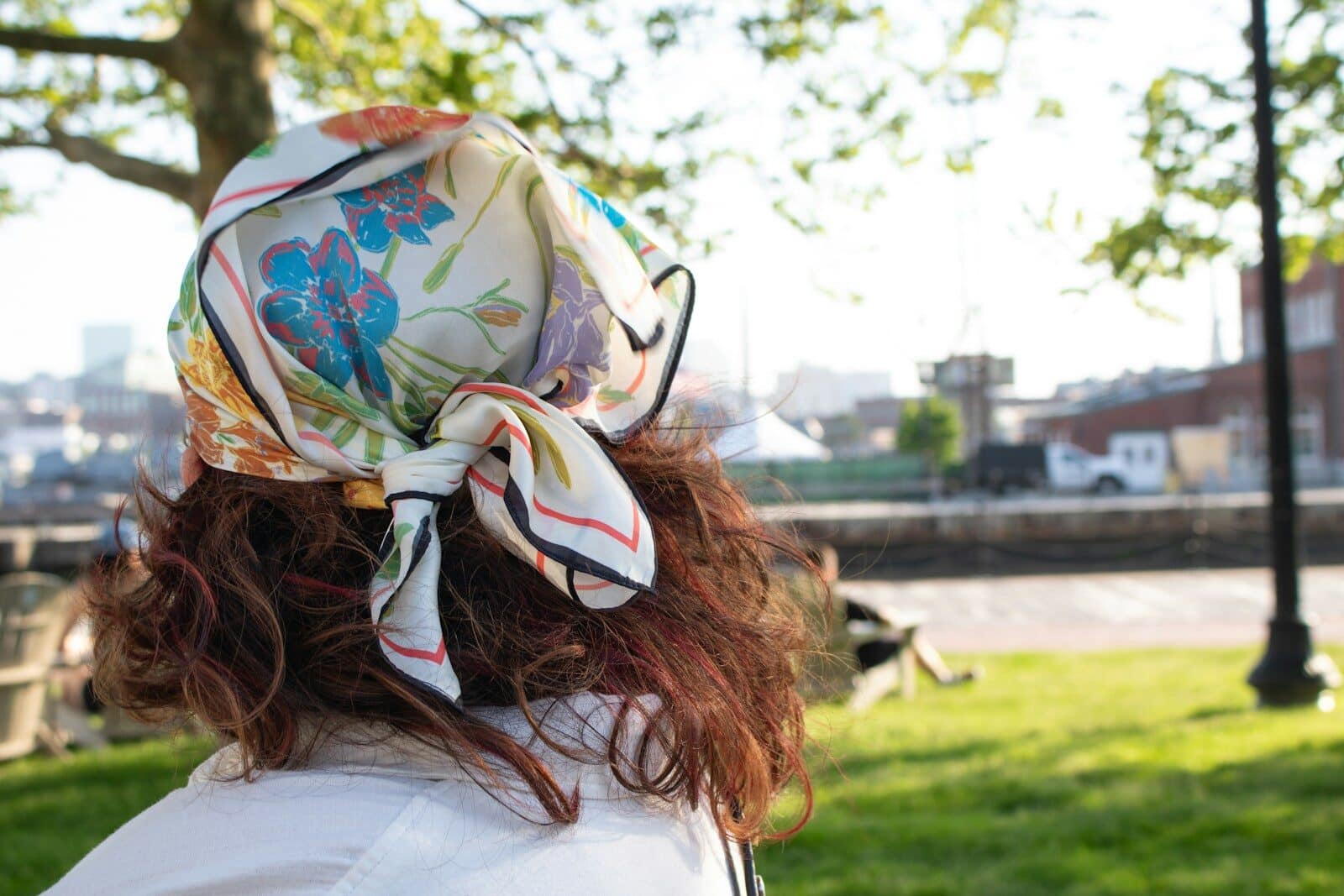 a woman in a park with a bandana on her head