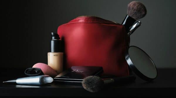red leather bag beside black makeup brush