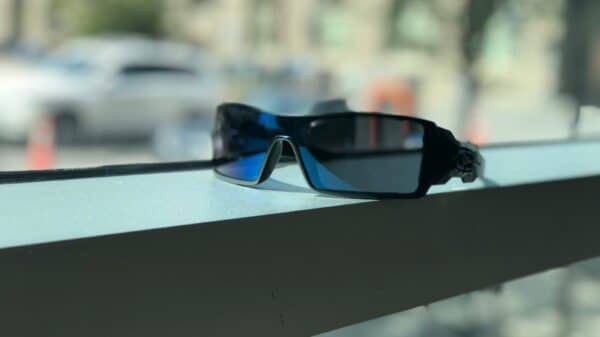 black framed blue lens sunglasses near window